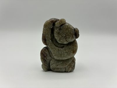 un gros plan d'une figurine d'ours en peluche posée sur une surface blanche