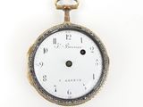 an antique pocket watch on a white surface with a white background