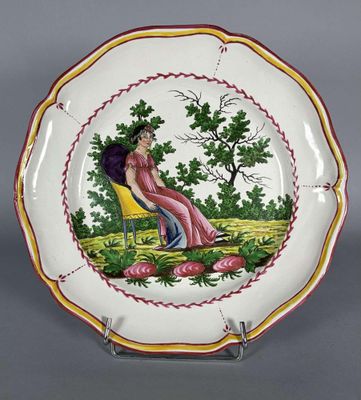 une image représentant une assiette décorative sur laquelle figure une femme assise sur une chaise