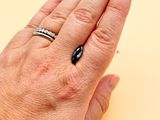 a woman ' s hand with a ring and a ring on it