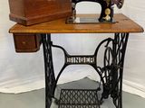 une vieille machine à coudre posée sur une table en bois