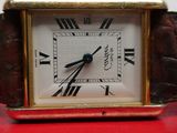 a small square clock with roman numerals on the face