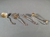 five silver spoons and two silver spoons on a table