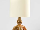 une lampe de table marron surmontée d'un abat-jour blanc
