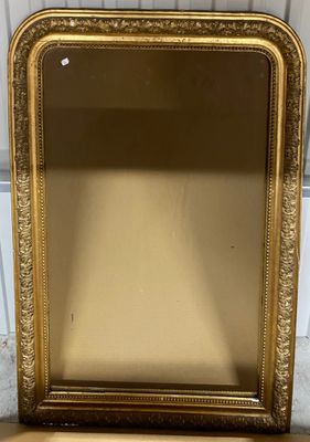a gold framed mirror sitting on top of a wooden table