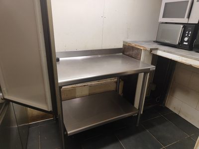 une table de travail en acier inoxydable dans un coin de la cuisine