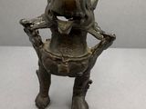 une photo d'une statue en bronze représentant un chien assis sur une chaise