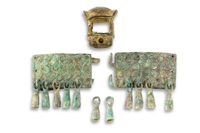 two pieces of metal with green and gold designs on them