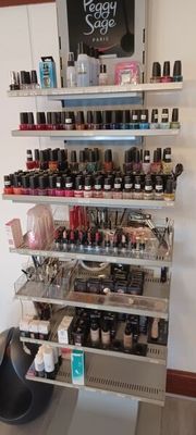 de nombreux flacons de vernis à ongles sur les étagères du salon