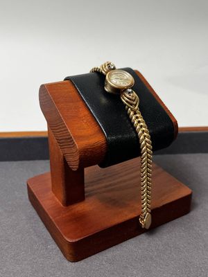montre-bracelet posée sur un support en bois muni d'une chaîne