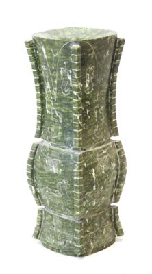 un vase vert orné de sculptures sur fond blanc