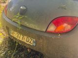 une voiture garée dans l'herbe près d'une clôture