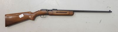 un fusil posé sur une table près d'un mur