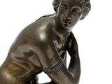 bronze statue of a woman crouching down with her hands on her knees