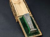 an old metal box with a green glass inside on a black surface