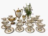 many cups and saucers that are sitting on the table