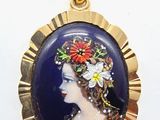 Un pendentif plaqué or représente une femme avec des fleurs dans les cheveux.