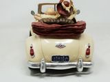 a figurine of a man in a car with a basket on the back of it