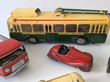 a lot of toy cars and a bus on a white surface