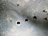 un gros plan sur un morceau de métal percé de trous