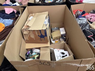 de nombreuses boîtes contenant des vêtements et d'autres objets, empilées les unes sur les autres