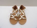 a close up of a pair of gold sandals on a white surface