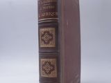 un vieux livre à la couverture marron posé sur une table blanche