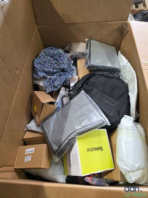 a cardboard box filled with items that include a backpack, books, and other items