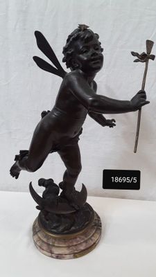 statue d'un petit garçon tenant un bâton et debout sur un rocher