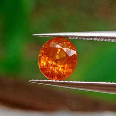 a close up of a yellow diamond being held by a pliers