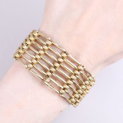 bracelet made of gold metal beads on a woman ' s wrist