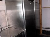 stainless steel refrigerators in a kitchen with black flooring and walls
