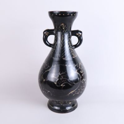 a black vase that is sitting on a white surface