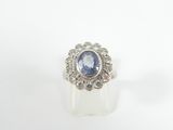 a close up of a ring with a blue stone surrounded by diamonds