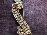 a close up of a gold chain with a coin on it