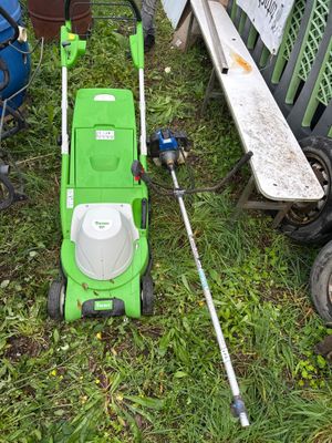 une tondeuse à gazon verte posée sur l'herbe, à côté d'autres tondeuses à gazon