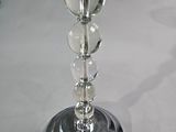 a glass table with a silver base and a glass candle holder