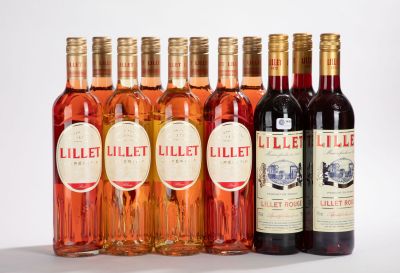 plusieurs bouteilles de vin sont alignées sur une surface blanche