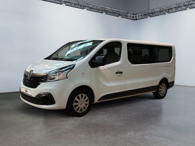 La camionnette blanche est garée dans une grande pièce aux murs blancs.