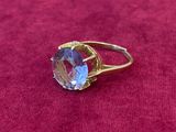 Gros plan sur une bague en or ornée d'une topaze bleue