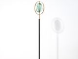 un lampadaire noir et doré surmonté d'un globe vert