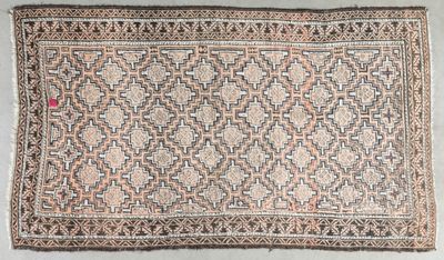 an old rug with a pattern on it on a white floor