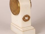 an image of a white and gold clock on a white surface