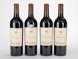 trois bouteilles de vin rouge sont alignées sur une surface blanche