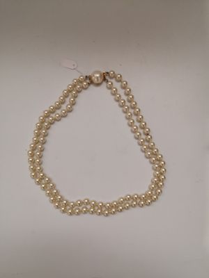 gros plan d'un collier de perles sur une surface blanche