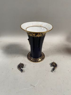 une paire de vases noirs et dorés posés sur une table blanche