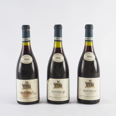trois bouteilles de vin posées les unes à côté des autres sur une surface blanche