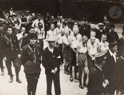 black and white photo of a group of men in uniform walking down a street