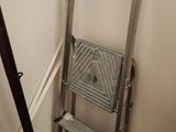 a ladder and a step stool in the corner of a room