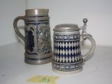 two beer mugs sitting next to each other on a table